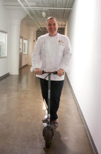 Chef Jacques Torres riding a scooter. Photo by Kara Chin.