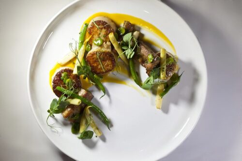 Seared pork belly and seared scallops with apricot sauce and beans (green wax and yellow wax and fava bean) with white asparagus