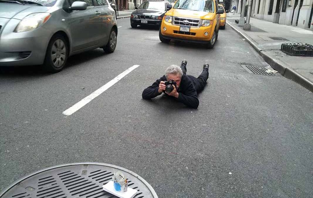Battman lying in the street taking pictures for the Street Eats book.