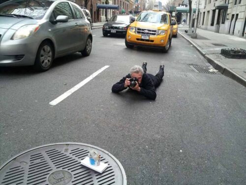 Battman lying in the street taking pictures for the Street Eats book.
